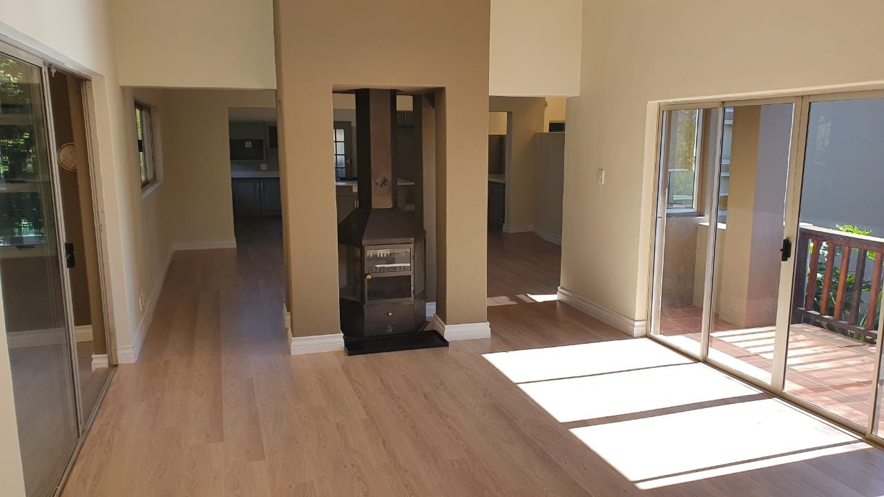 An empty living room with hardwood floors and sliding glass doors