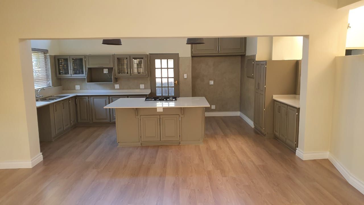 An empty kitchen with a large island in the middle