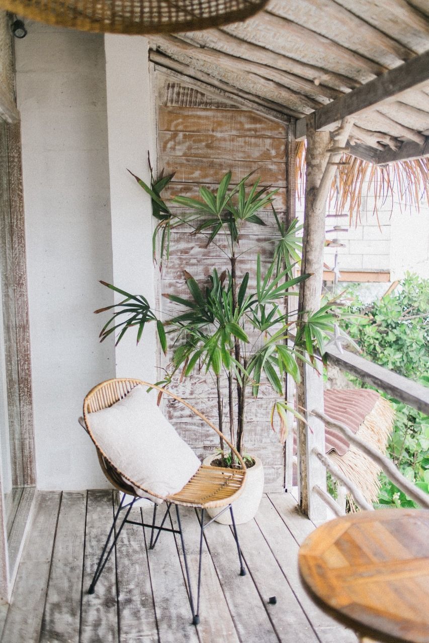 A balcony with a chair and a potted plant on it.