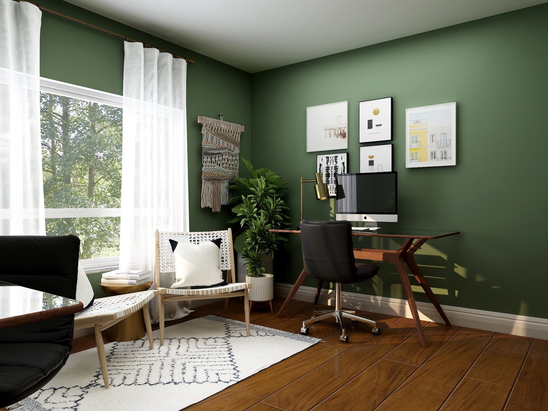 A home office with green walls , a desk , chairs , and a computer.