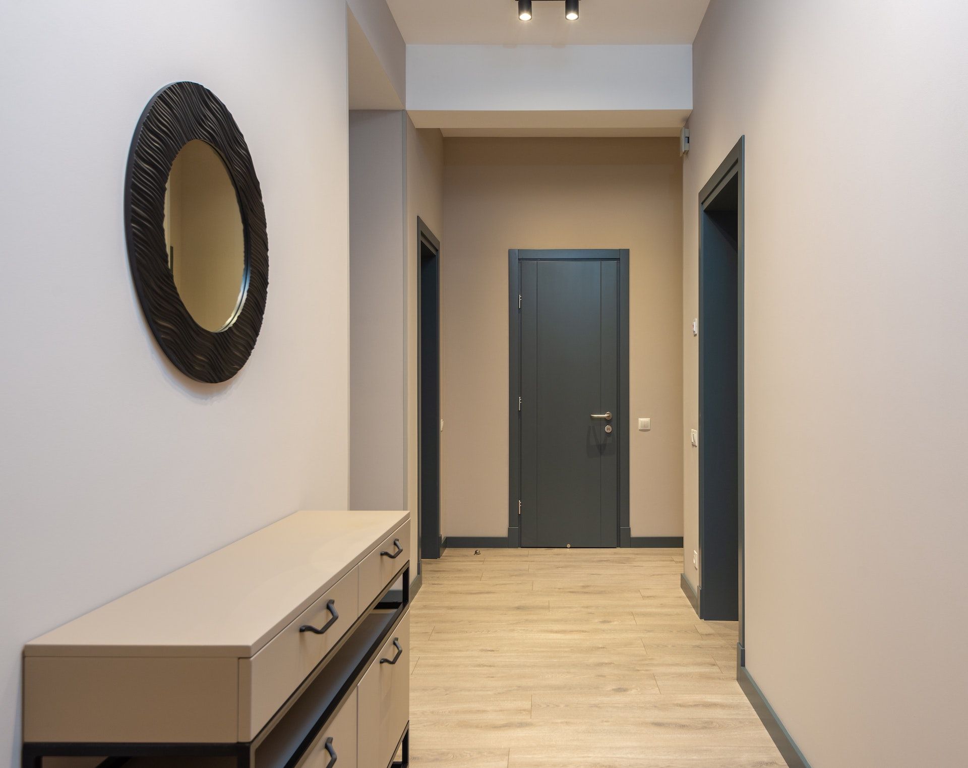 There is a mirror on the wall in the hallway.
