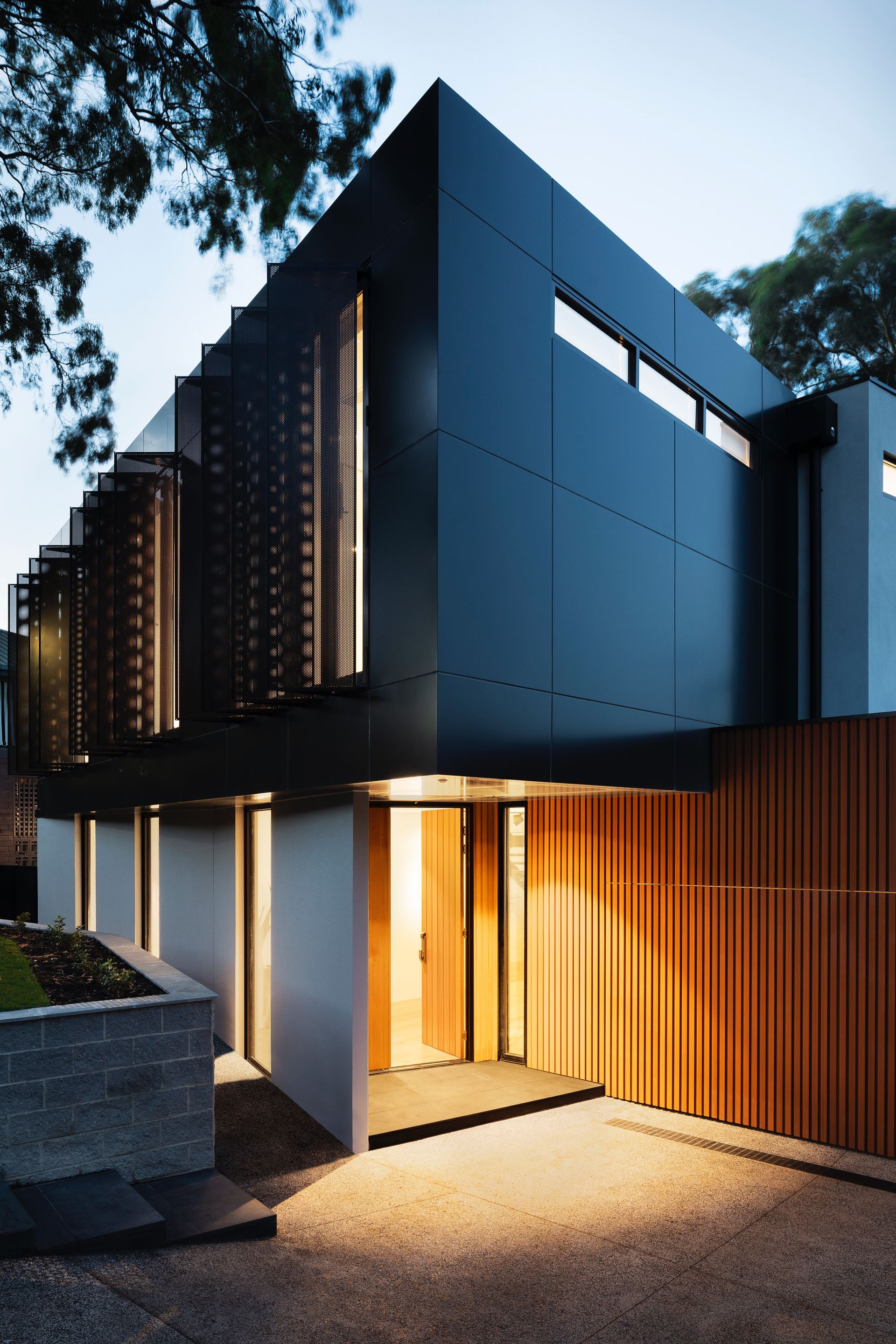 A modern house with a black facade and wooden siding