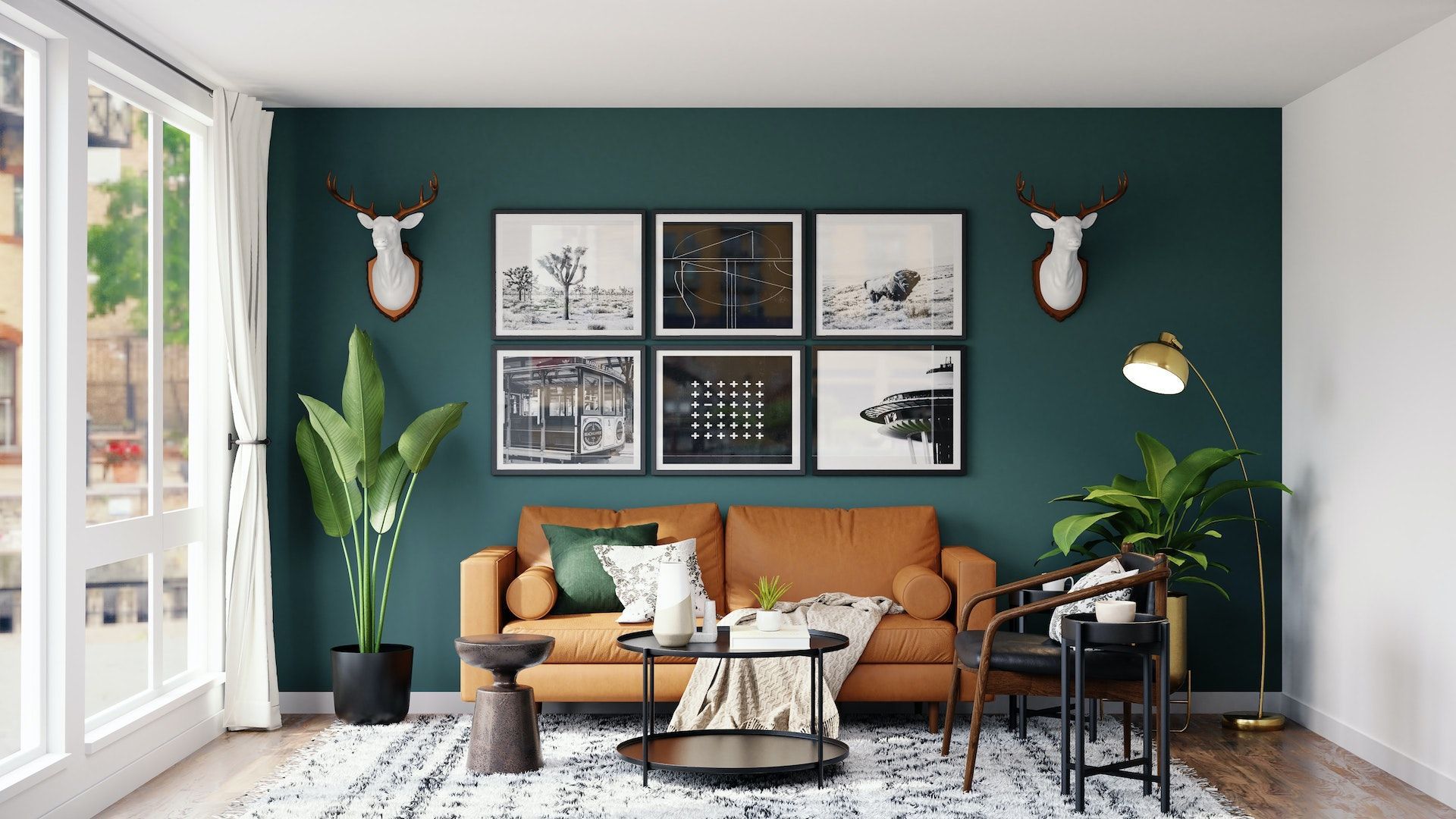 A living room with a couch , coffee table , chairs and a green wall.