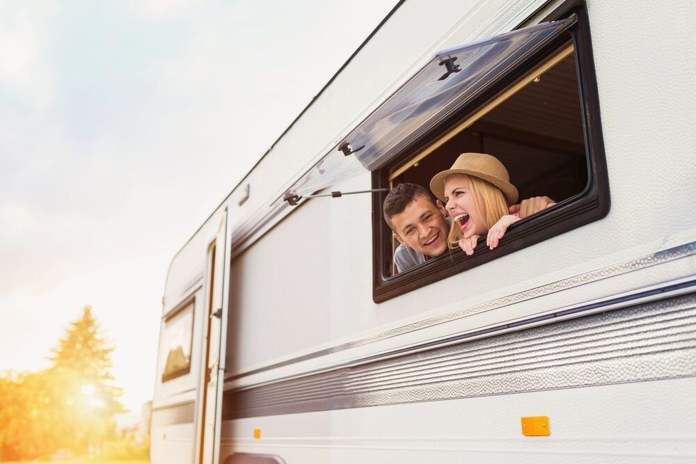 A Man and a Woman Are Looking Out of a Camper Window — Strut Re-gas Mackay In Airlie Beach, QLD