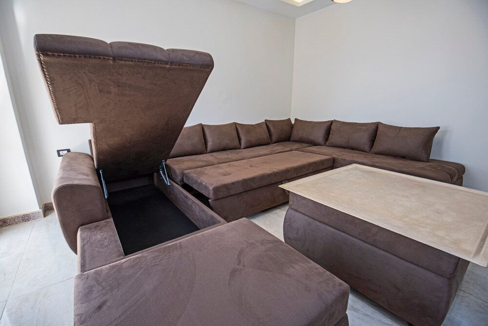 A Living Room With a Large Sectional Couch and a Coffee Table — Strut Re-gas Mackay In Moranbah, QLD