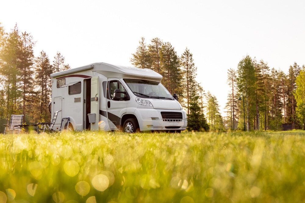 A Rv is Parked in a Grassy Field in the Woods — Strut Re-gas Mackay In Ooralea, QLD