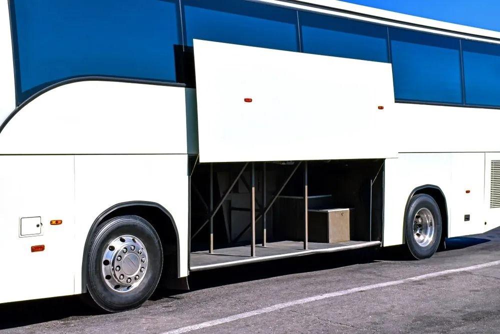 A White Bus with The Back Door Open Is Parked on The Side of The Road — Strut Re-gas Mackay In Ooralea, QLD