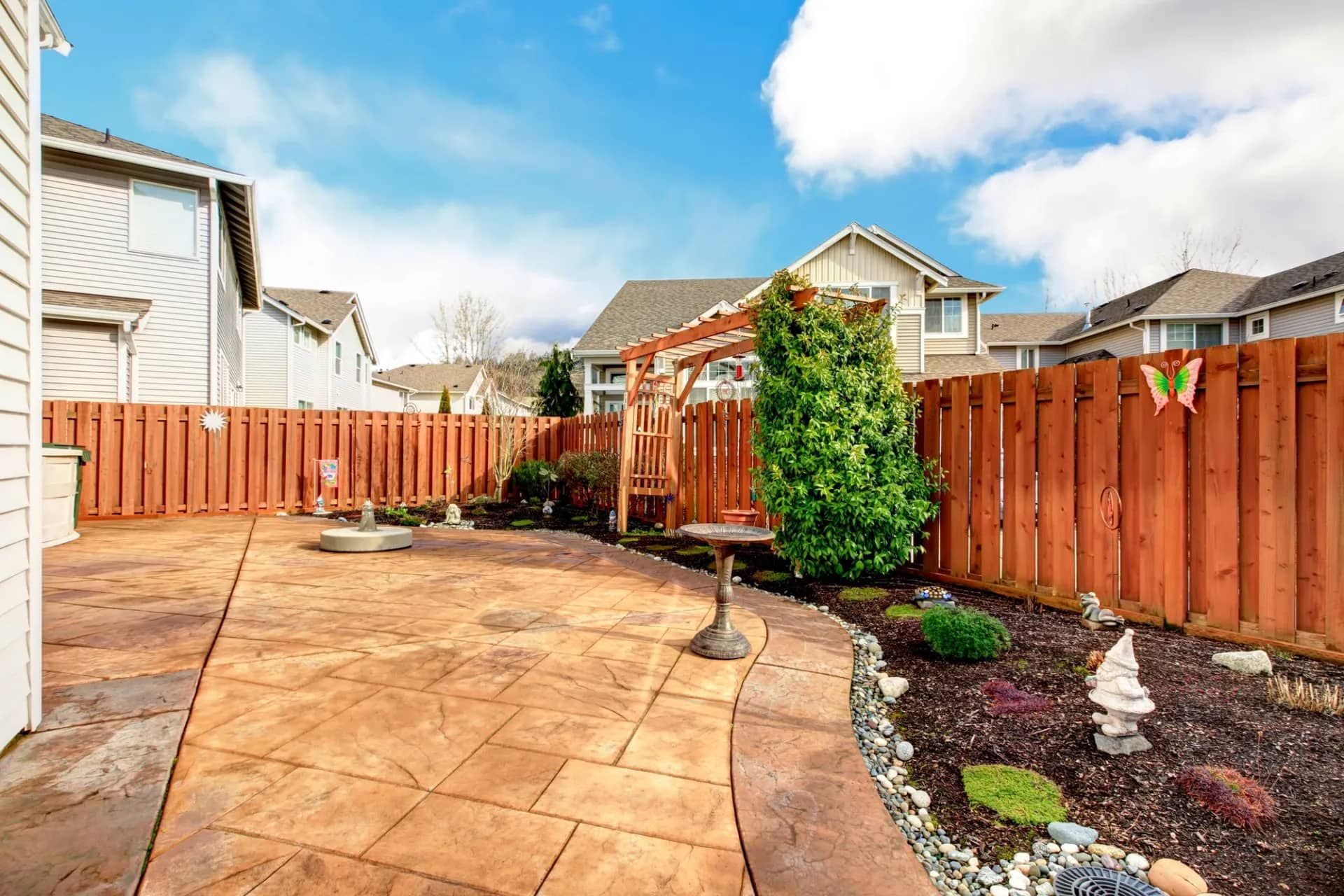 A backyard with a wooden fence and a patio.