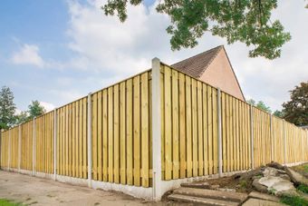 A wooden fence is in front of a house