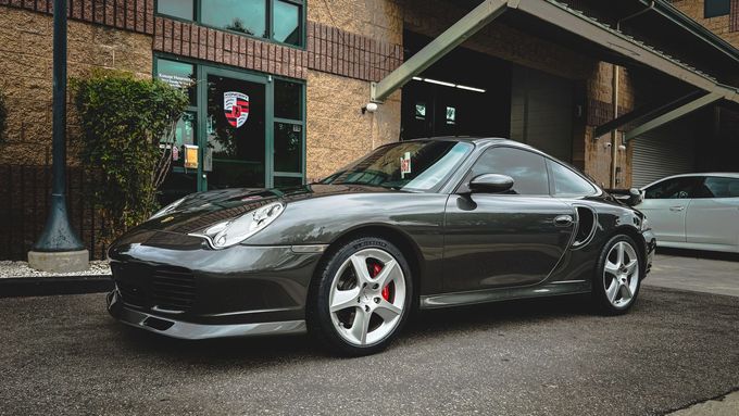 Dark gray Porsche sports car parked in front of the auto shop | Koncept Motorwerks
