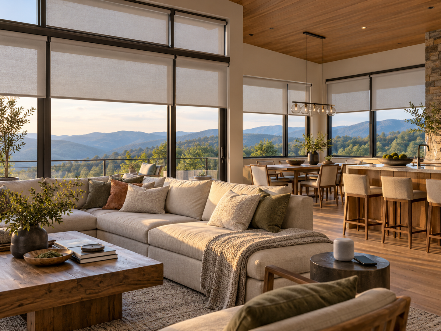 Modern living room with large windows with motorized roller shades, wooden coffee table, dining area, and mountain view