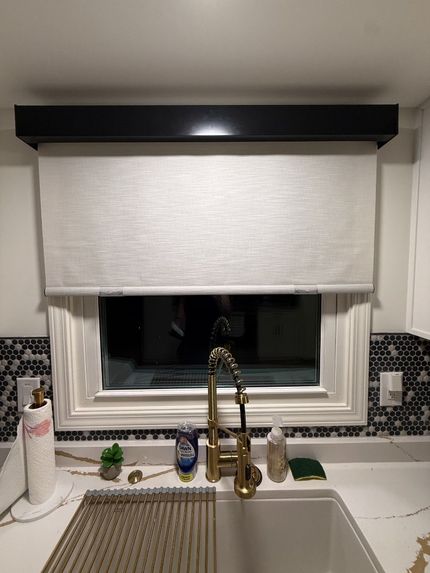 Kitchen with a bay window, white shutters, and a granite countertop. A black faucet sits over the sink.