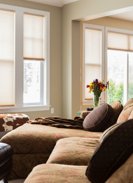 Window with light filtering through venetian blinds, white pitcher on windowsill.