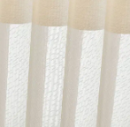 White textured curtains hanging in front of a window, softly lit by daylight