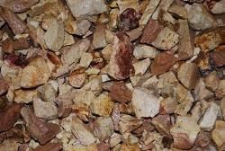 Close-up of a pile of mixed brown and beige pebbles and rocks