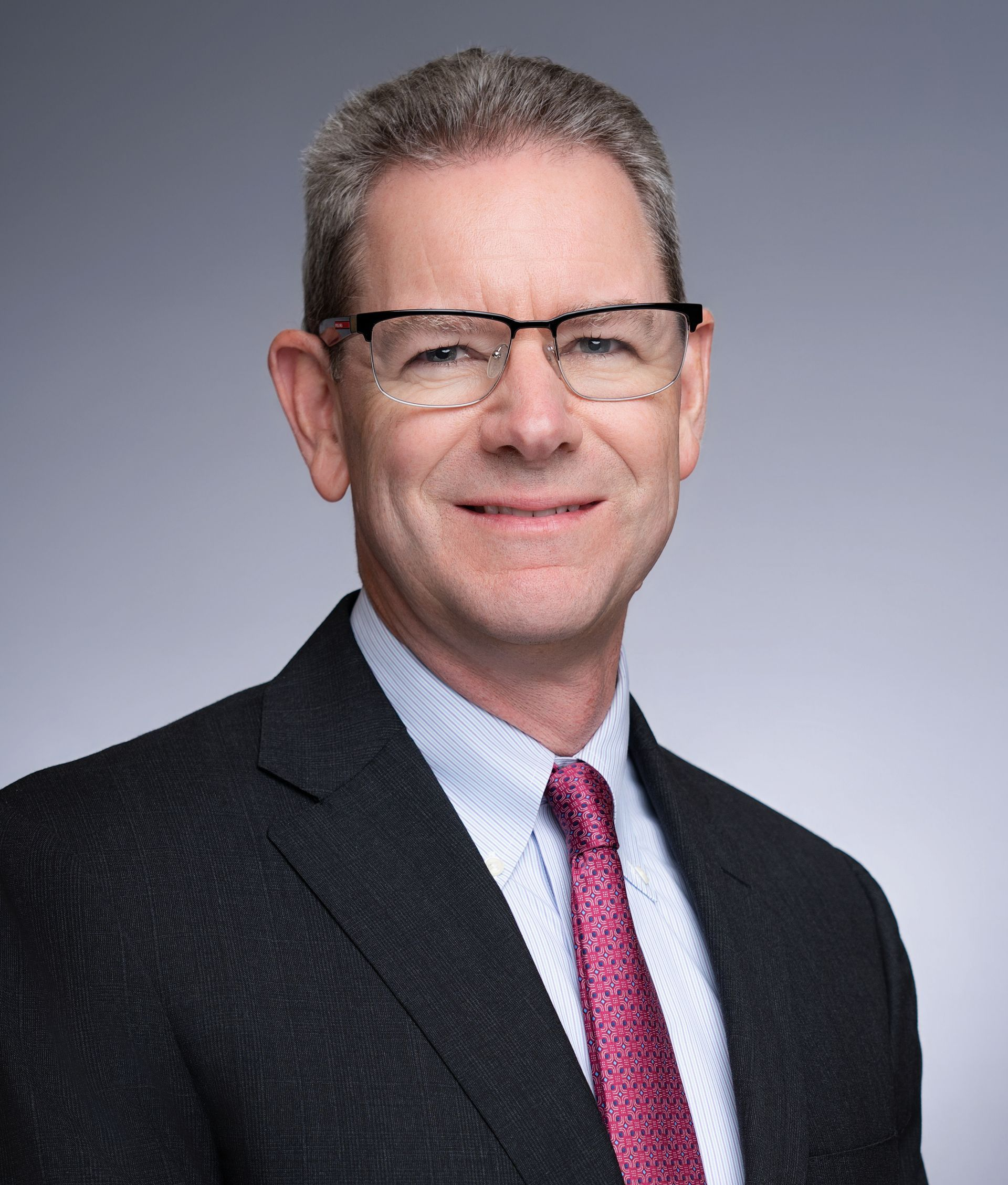 A man in a suit and tie is smiling for the camera.