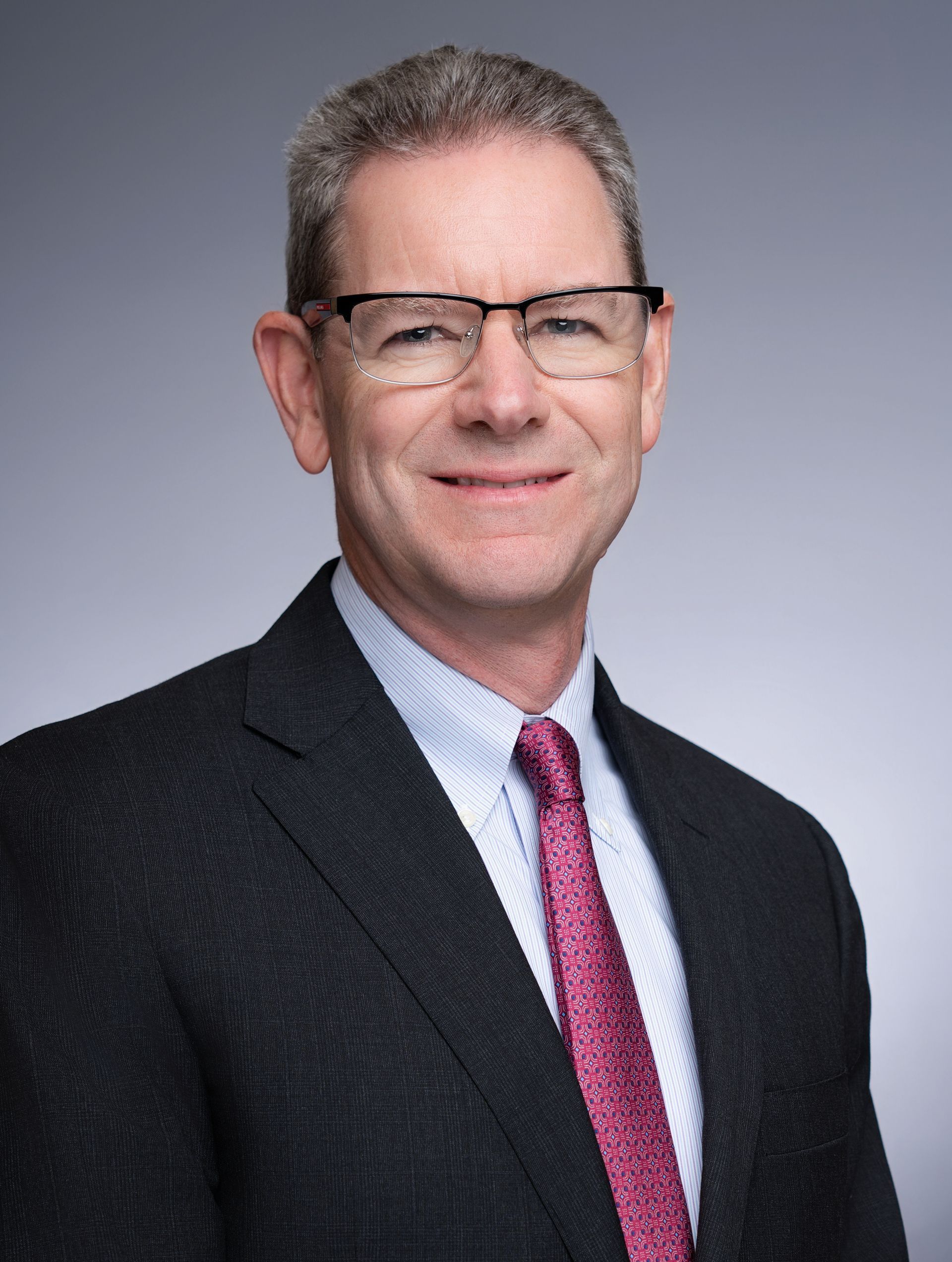 A man in a suit and tie is smiling for the camera.