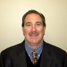 A man in a suit and tie is smiling for the camera.