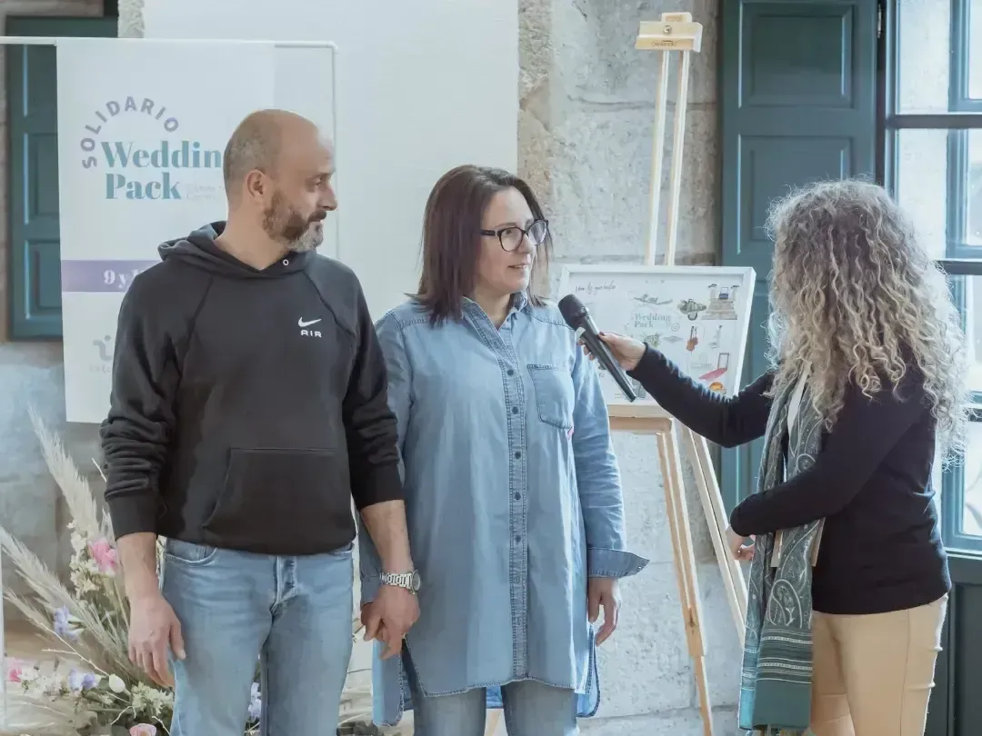Un hombre y una mujer están uno al lado del otro y una mujer habla por un micrófono.