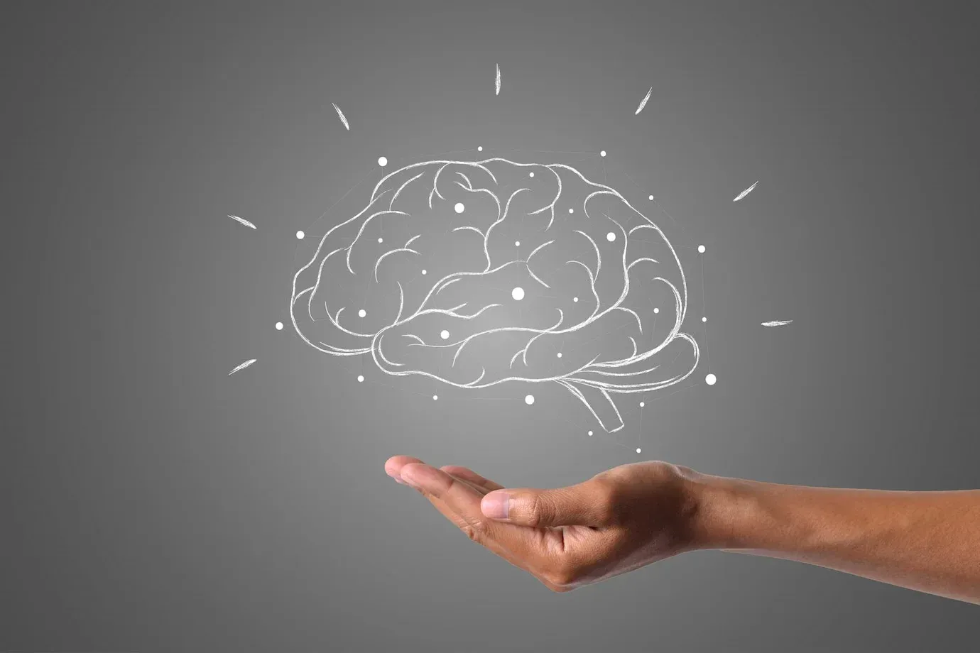 Una persona sostiene un dibujo de un cerebro en la mano.