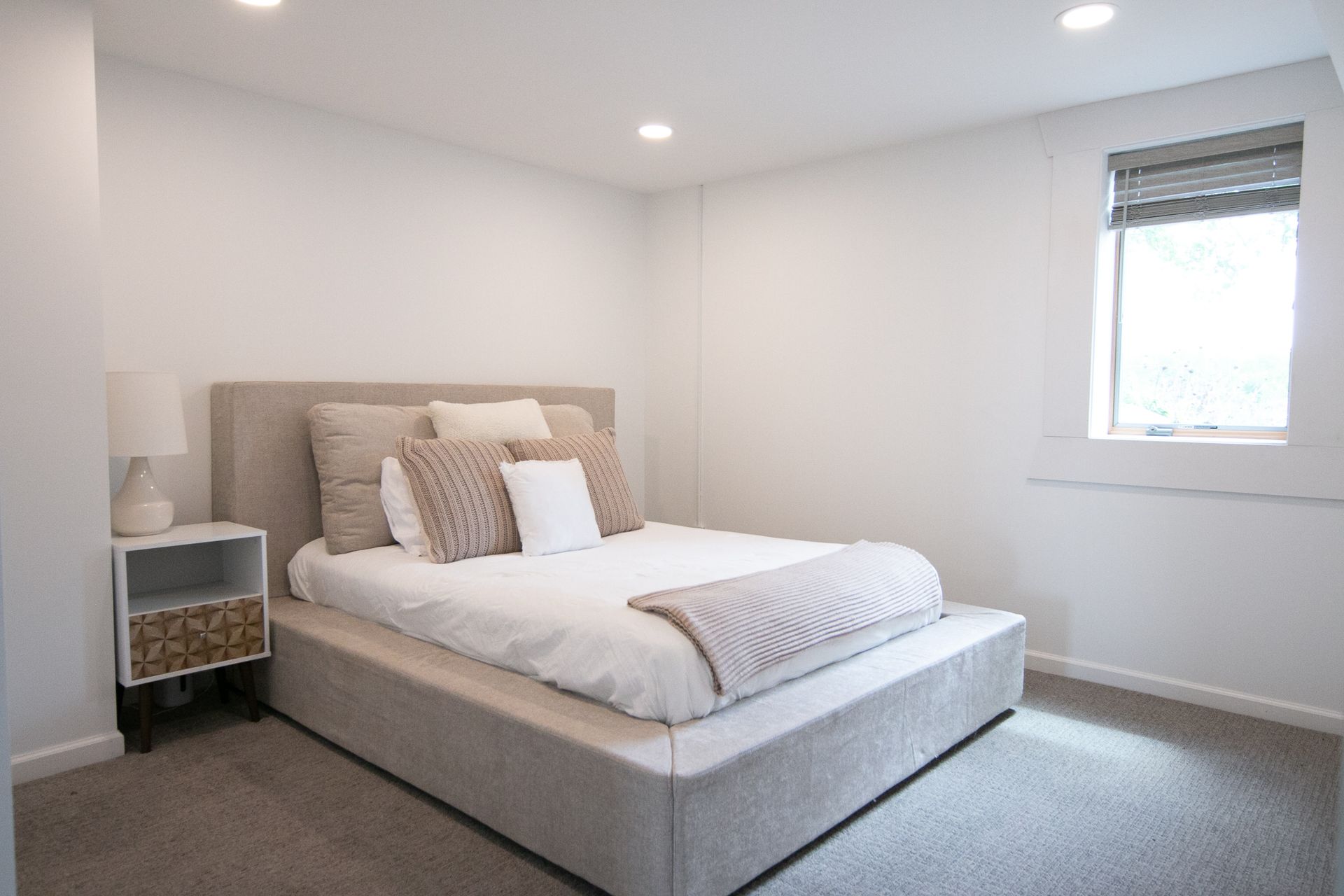 A bedroom with a large bed and a window.