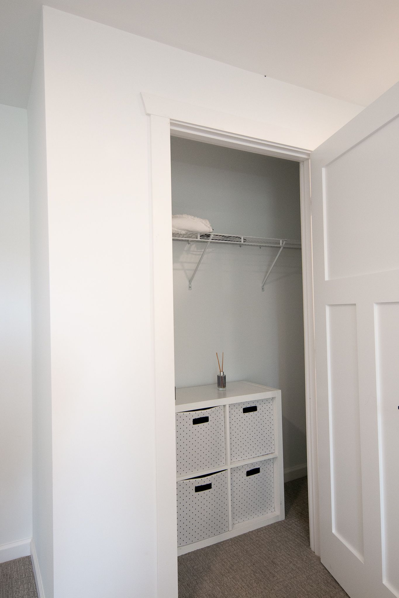 A walk in closet with a shelf and baskets in it.