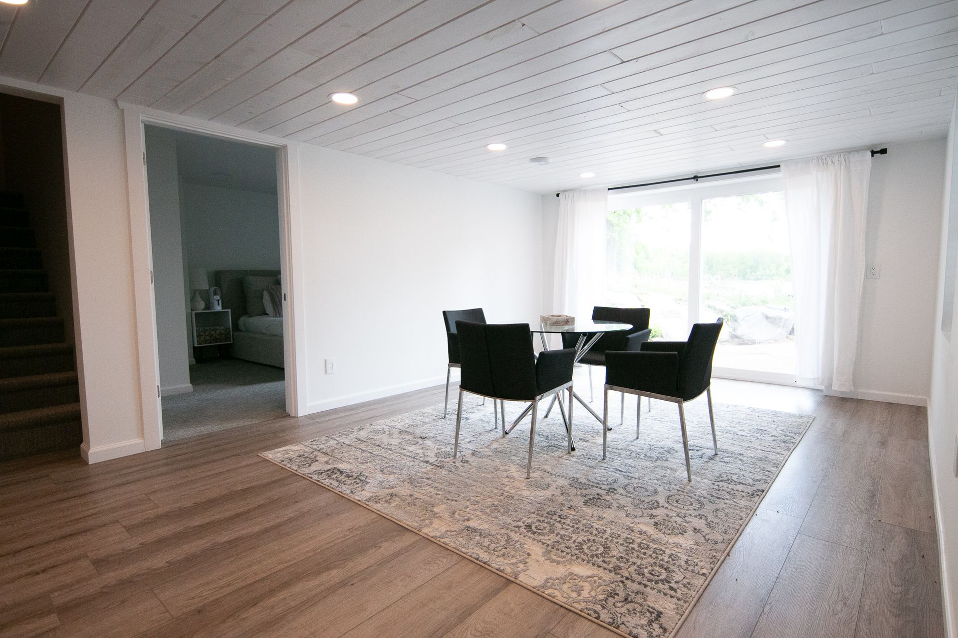 A dining room with a table and chairs and a rug.