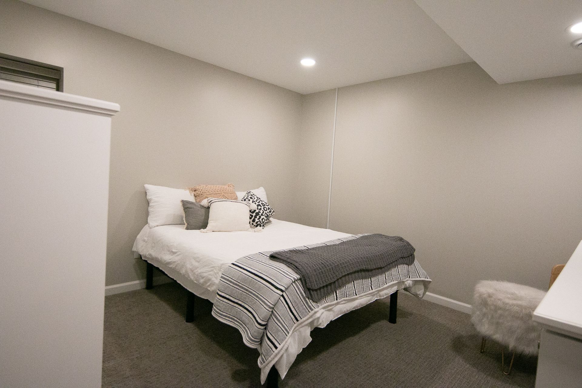 A bedroom with a bed , chair and dresser.