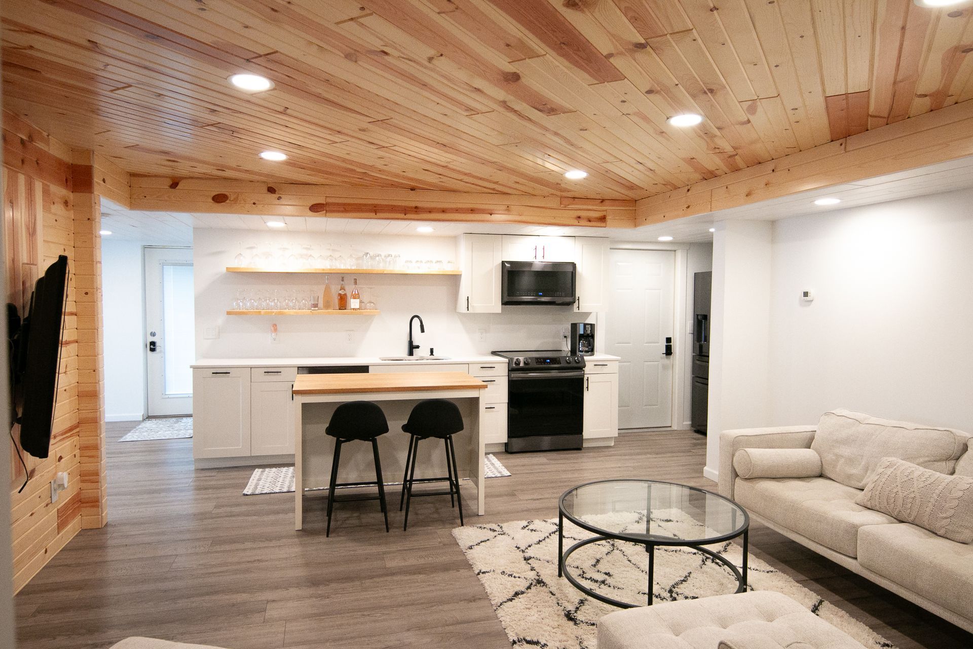 A living room with a couch , coffee table , and kitchen.