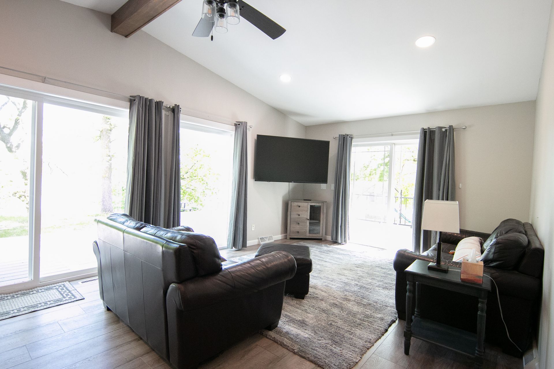 A living room with a couch , chair , table and television.