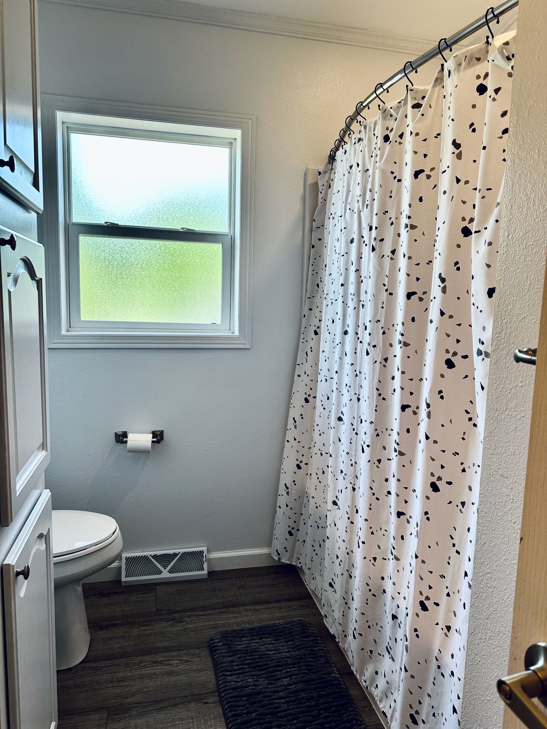 A bathroom with a shower curtain and a toilet