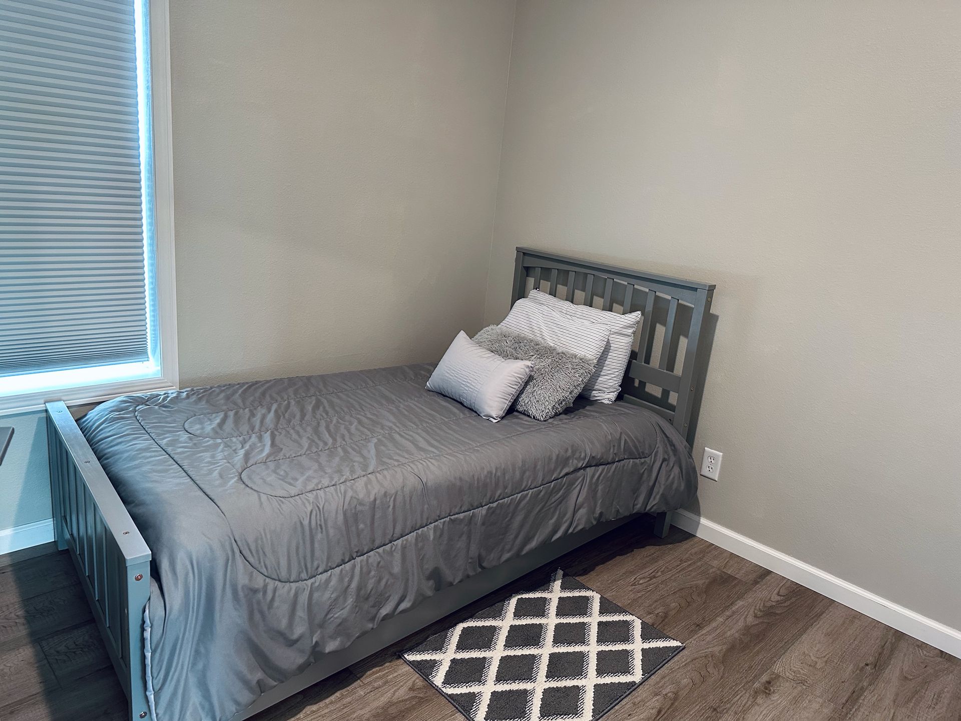 A bedroom with a single bed and a window.