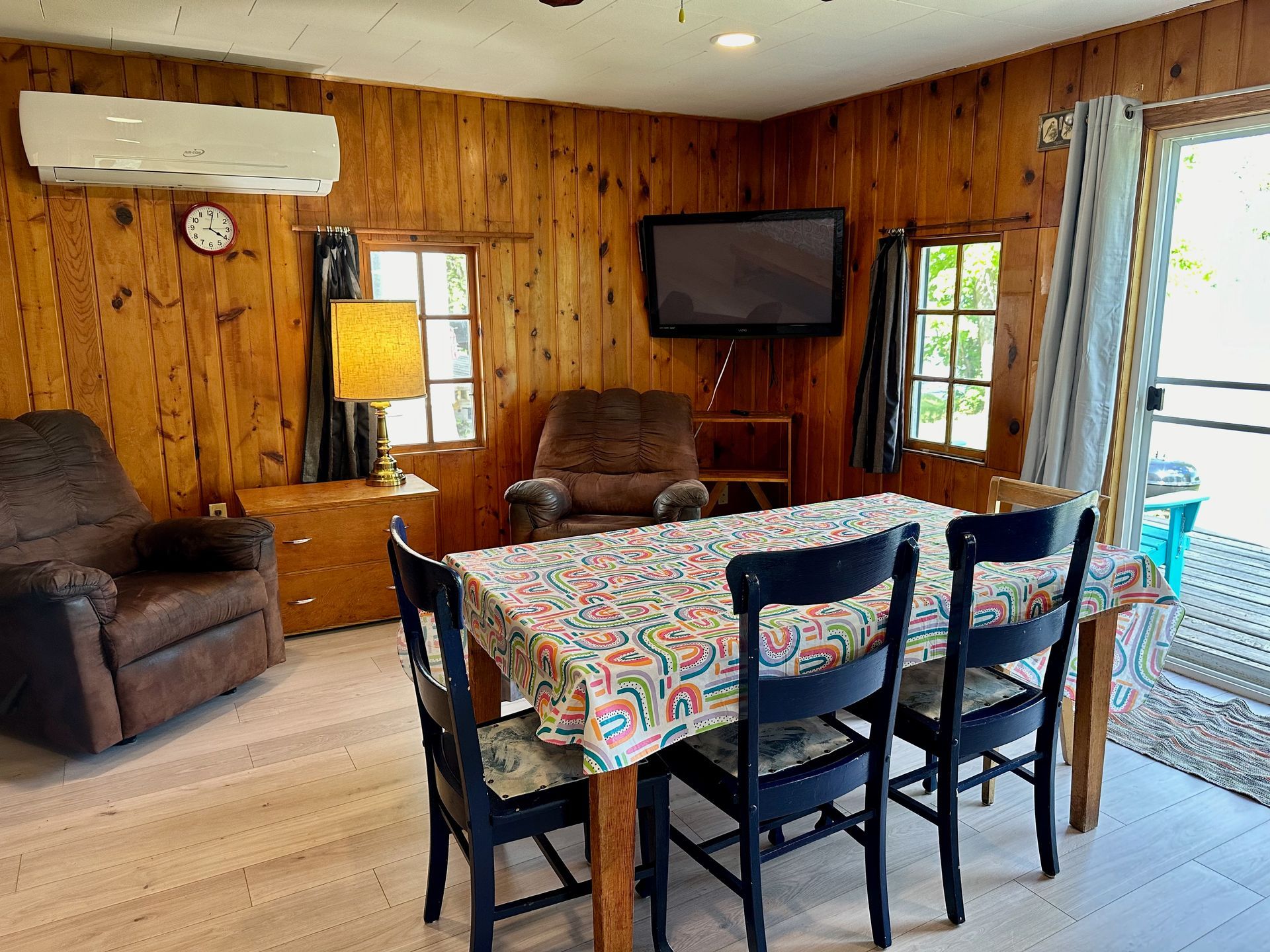 A living room with a table and chairs and a television.