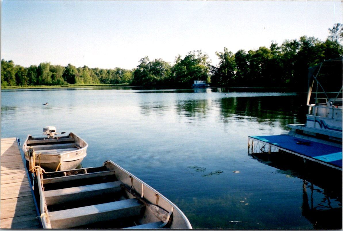 Two boats are docked at a dock on a lake