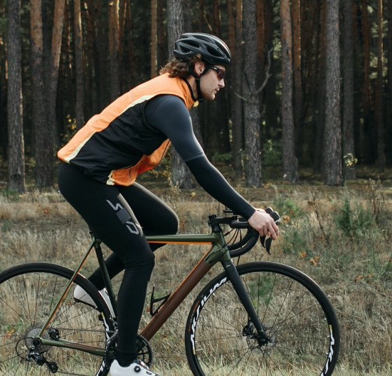 A man wearing a helmet is riding a bike in the woods