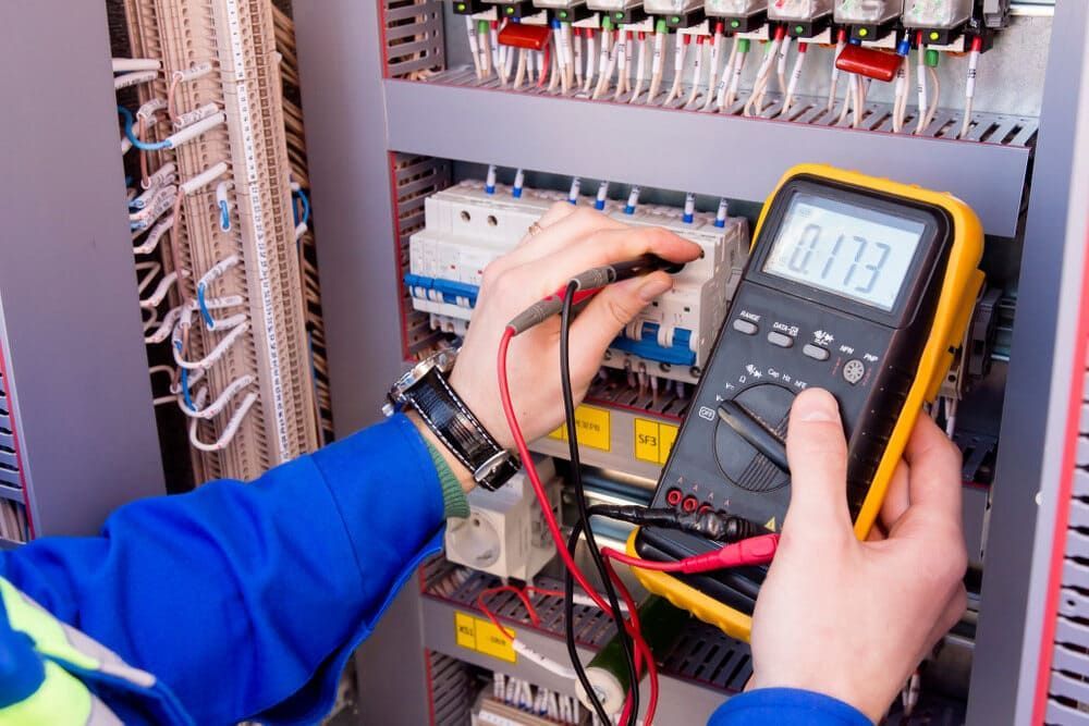 An Electrician Is Using A Multimeter To Test A Circuit Board — Allpower Electrical Wholesalers Pty Ltd In Innisfail, QLD