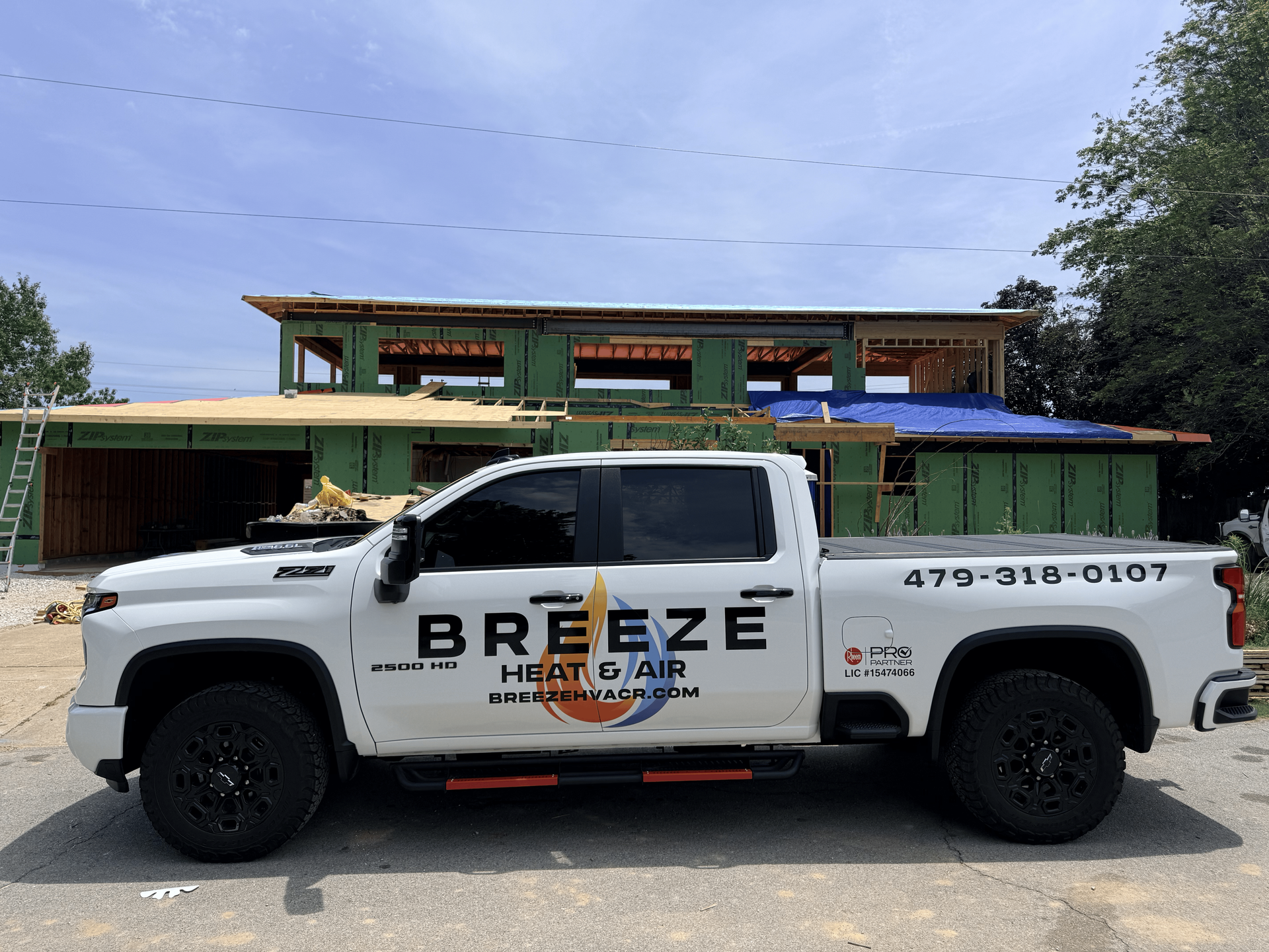 White Breaze service truck parked in front of a house under construction.