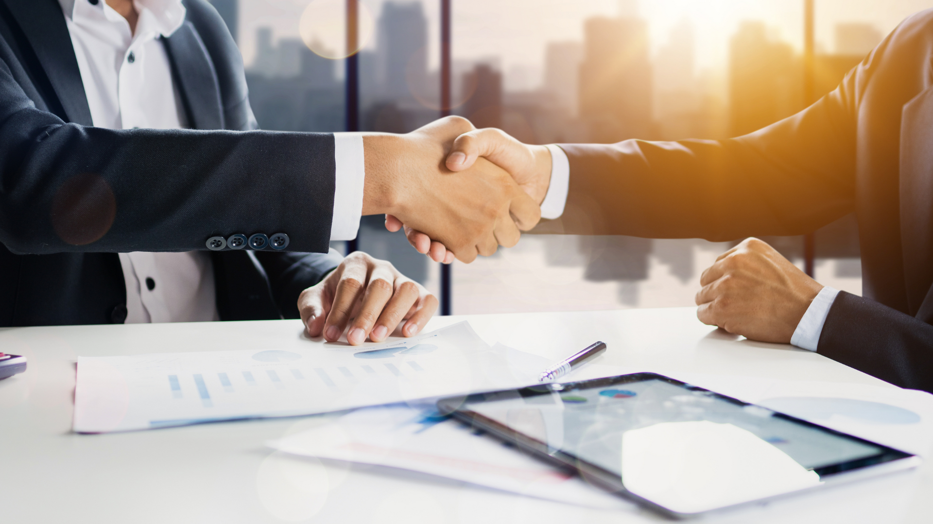 Two people shaking hands in a corporate setting. 