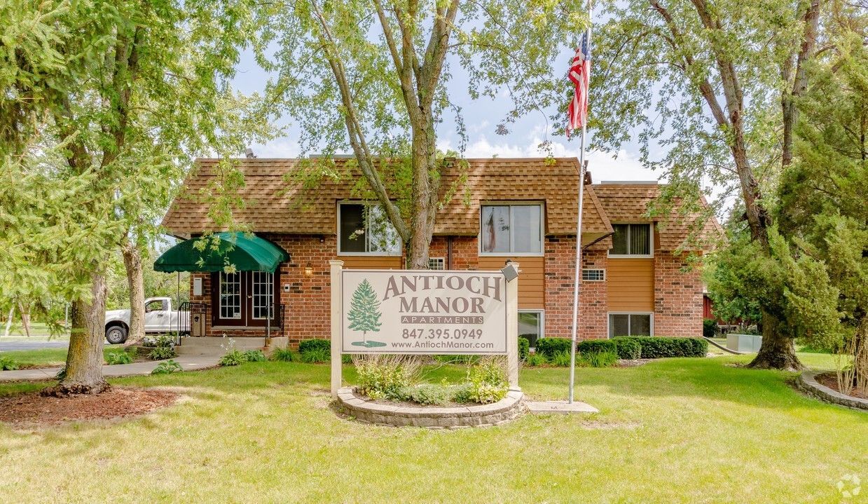 A large brick building with a sign in front of it.