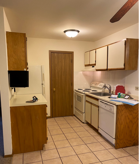 A kitchen with wooden cabinets and white appliances