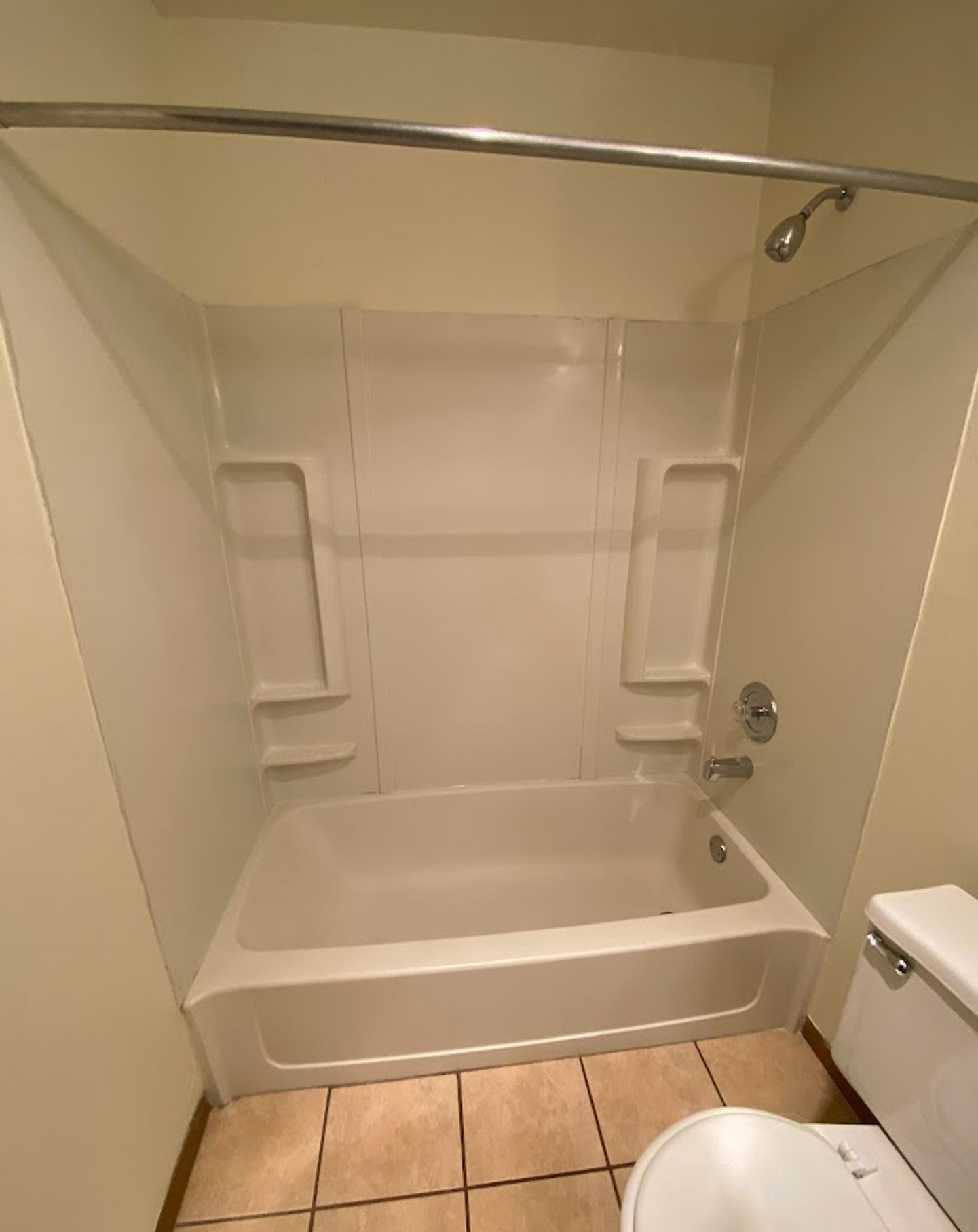 A bathroom with a bathtub , toilet and shower.