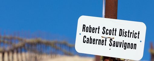 A white sign against a blue sky reads