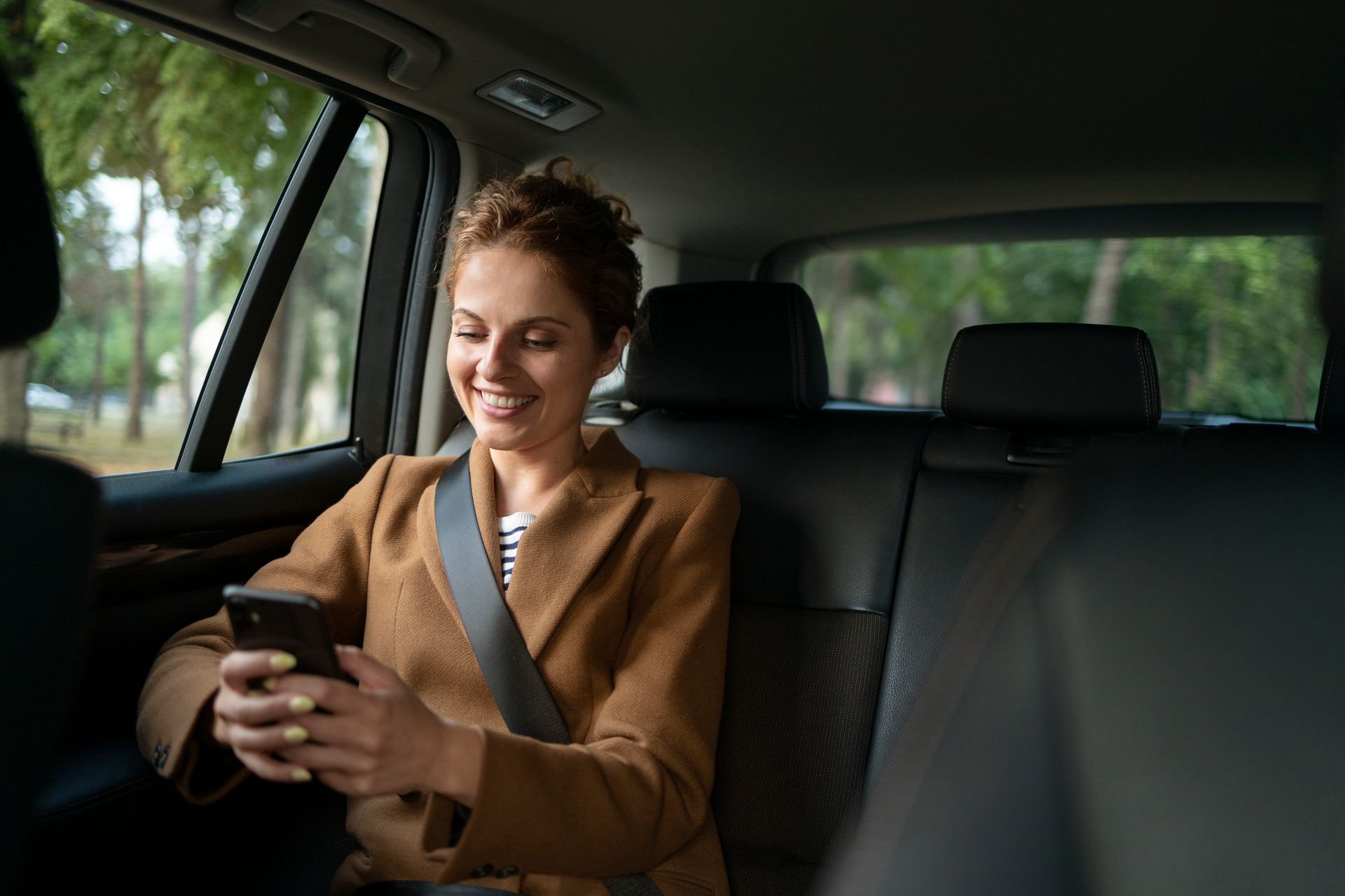 Lady enjoying a comfortable private transfer in the back seat of a car, representing a premium private transfer services across Portugal and Spain.