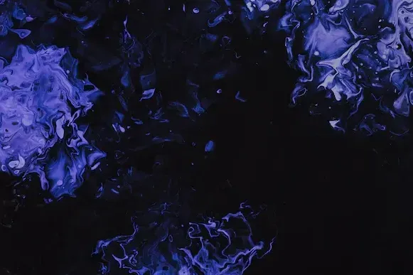 Abstract dark background with vibrant purple and blue swirling fluid textures on the sides.