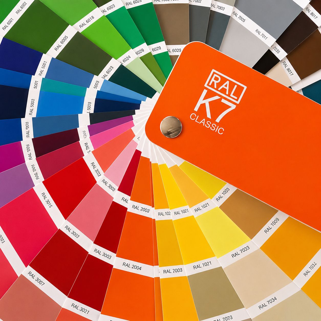 Pantone-style color fan deck with bright swatches fanned around an orange RAL K5 Classic cover