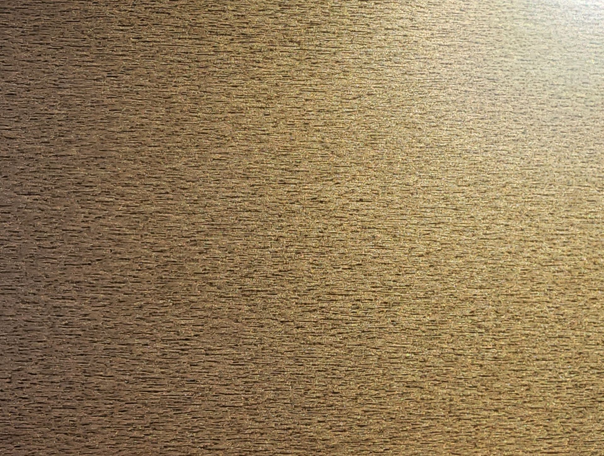 Close-up of a tan textured fabric surface with a darker shadowed edge on the right.