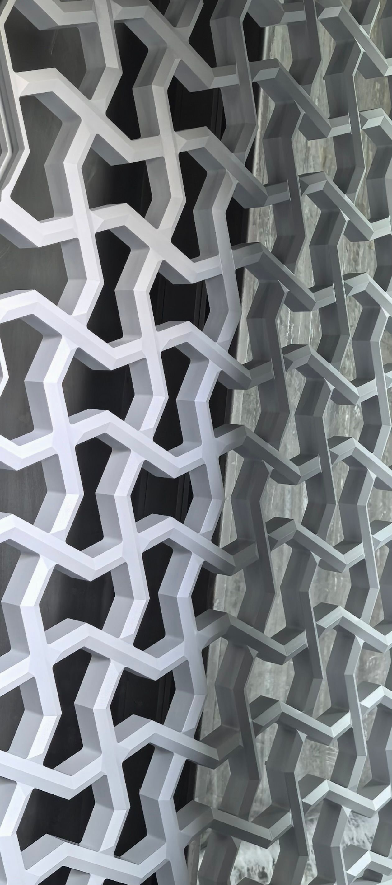Close-up of a geometric metal lattice with white and gray interlocking patterns