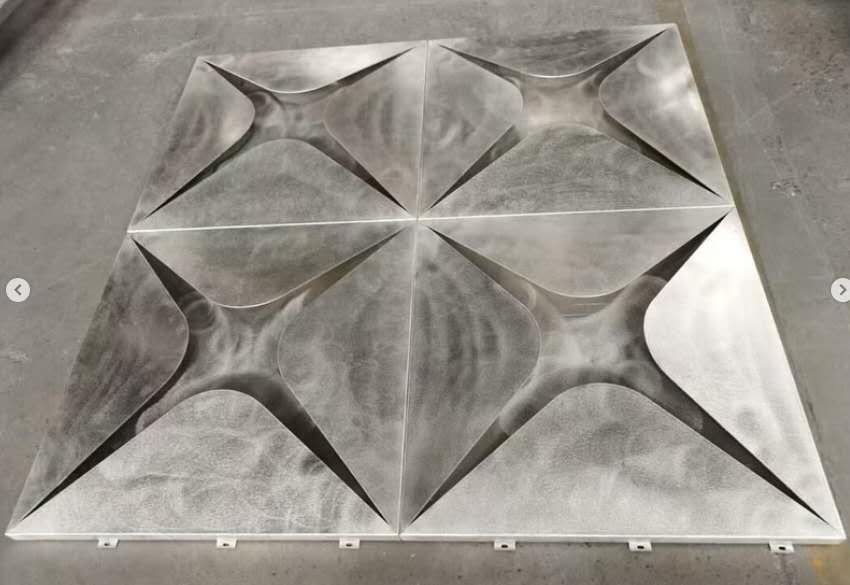 Gray geometric 3D wall panel with folded triangular facets on a smooth square surface
