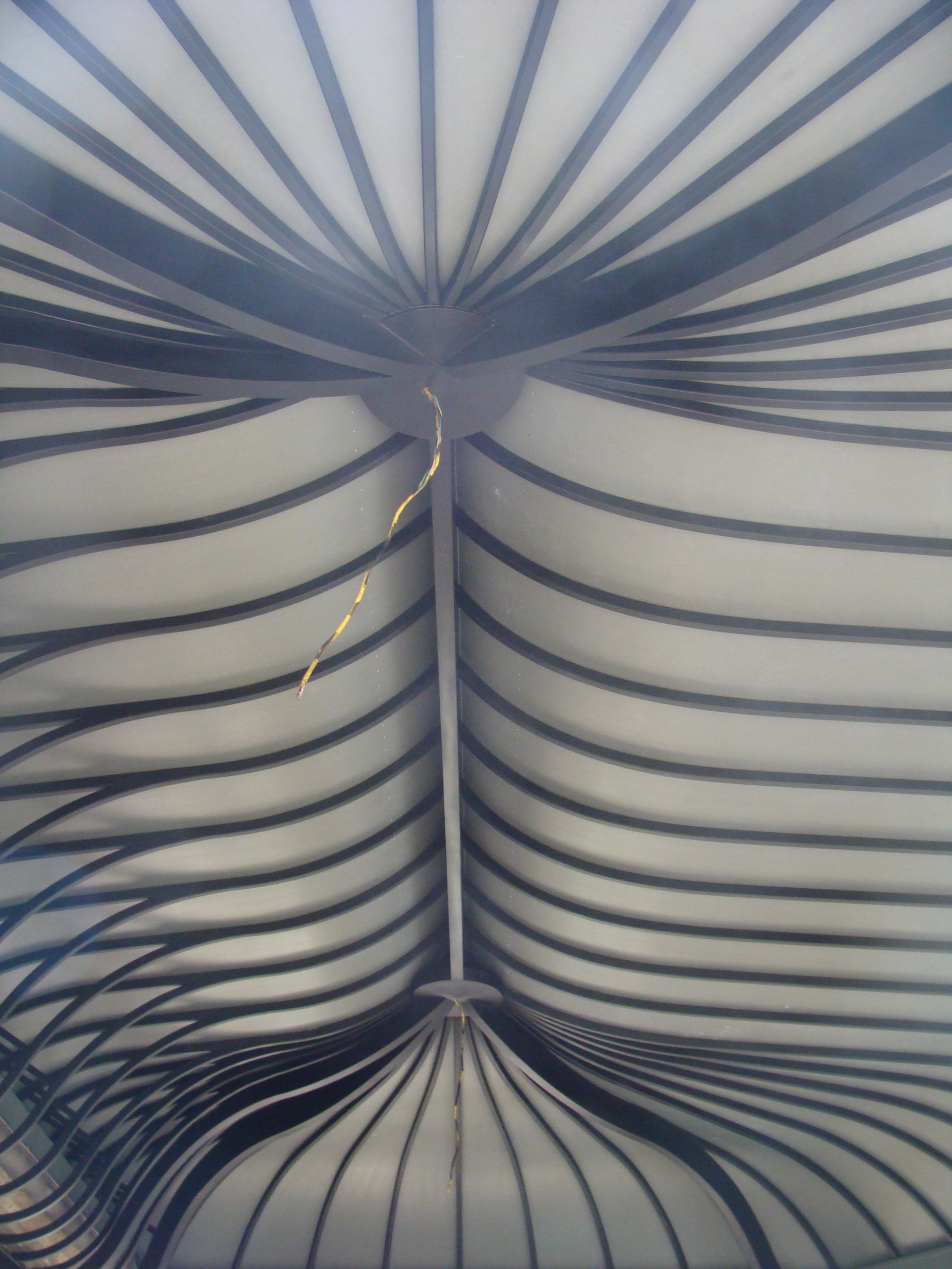 Blue-and-white striped fabric canopy viewed from below, forming a symmetrical tent-like pattern