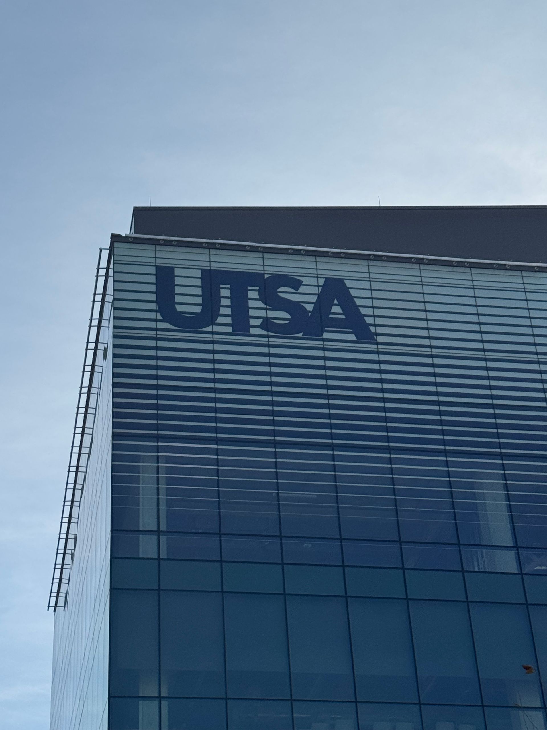 USA logo on a glass building against a blue sky